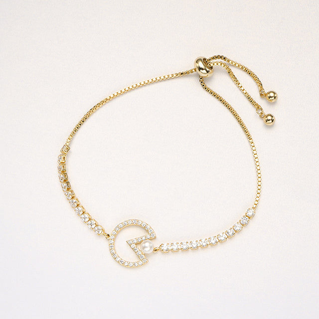 Gold eatting pearl adjustable bracelet on beige paper.