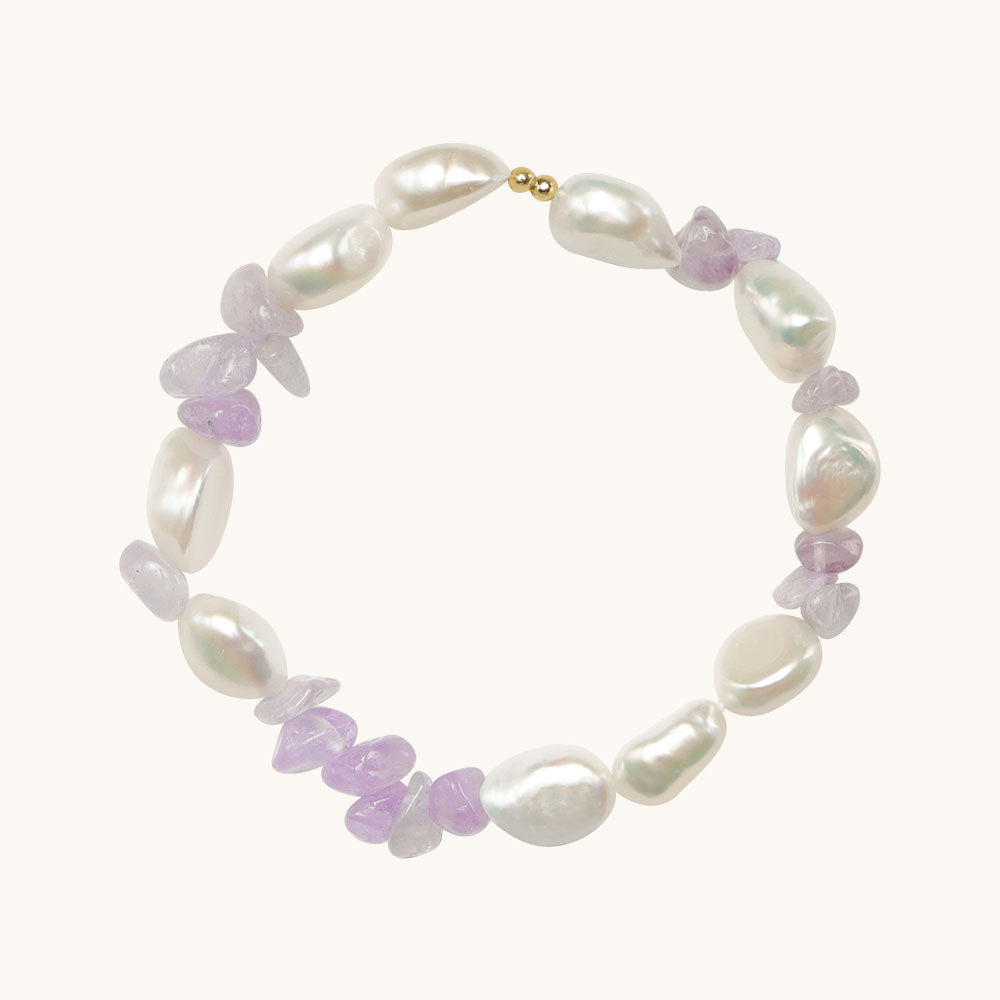 Amethyst stone bracelet with two gold beads on it.