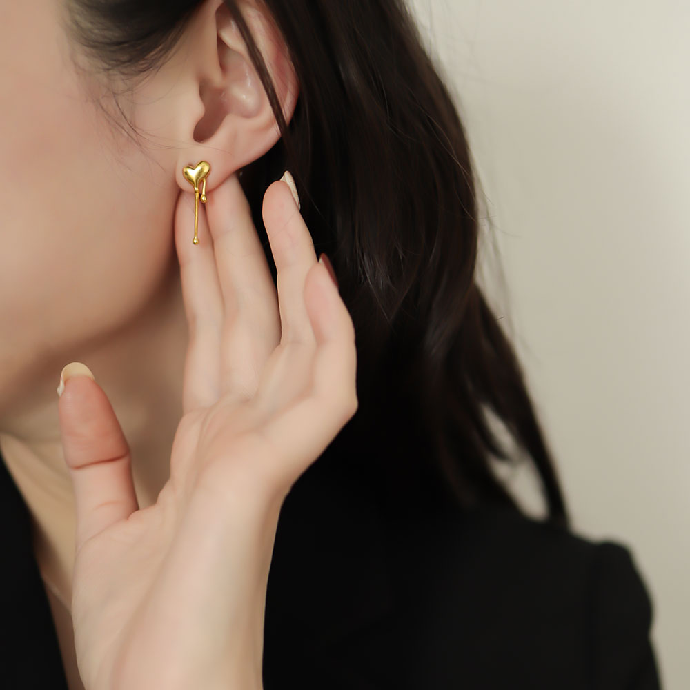 Women wear asymmetrical earrings in gold.