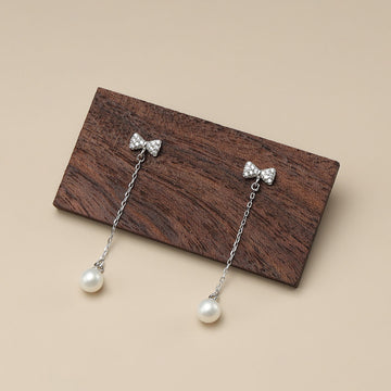 Bow bangle pearl earrings.