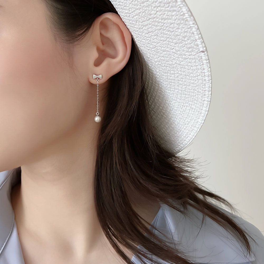 Women wear bow drop pear earrings.