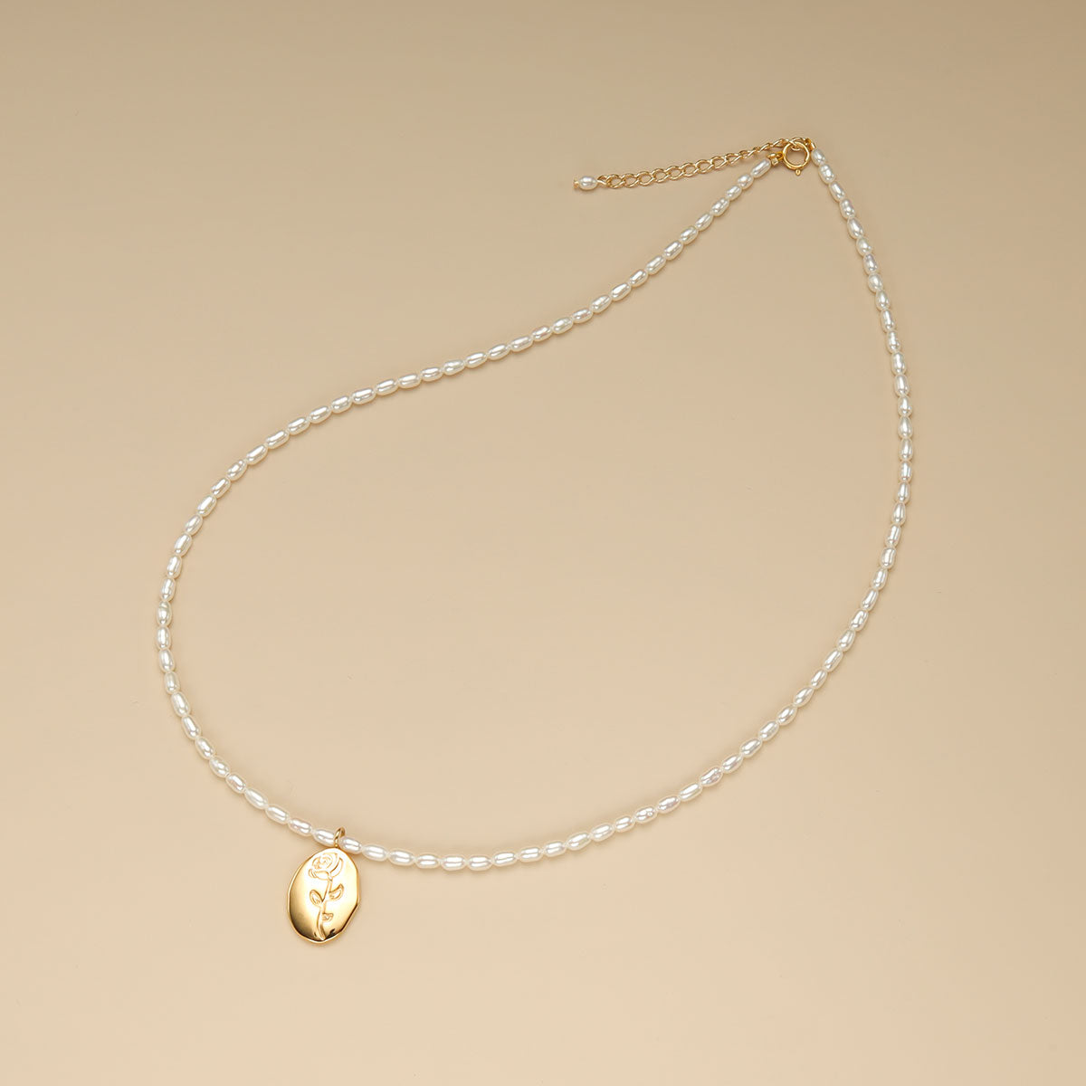 A charm pearl necklace with spring ring clasp.