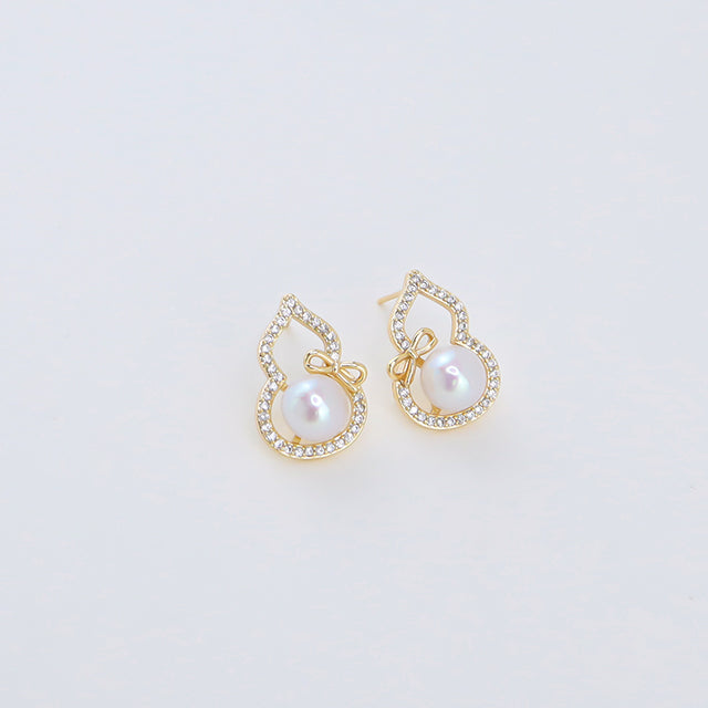 A pair of dainty gold earrings with diamonds.