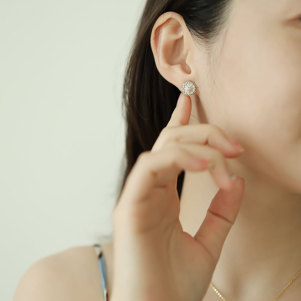 Women wear designer stud earrings.