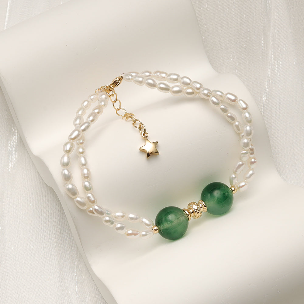 A double layer pearl bracelet with two green stone beads and star clasp.