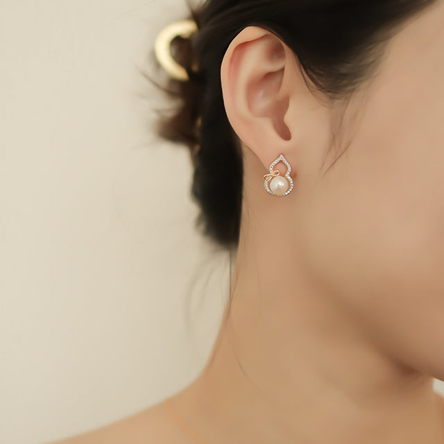 Pearl ear stud on women ear.