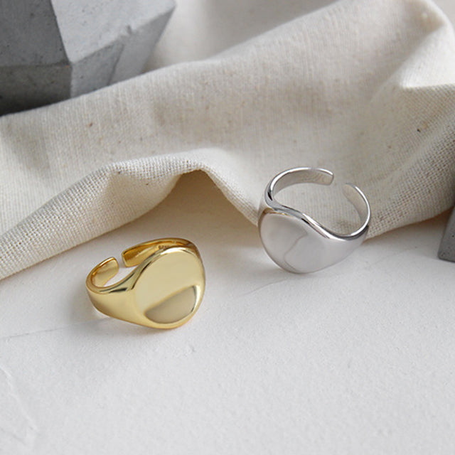 Two fashion gold plated signet rings on rutic cloth.