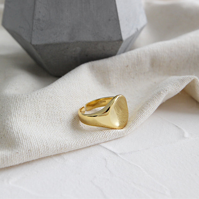 A gold circle ring on rutic cloth.