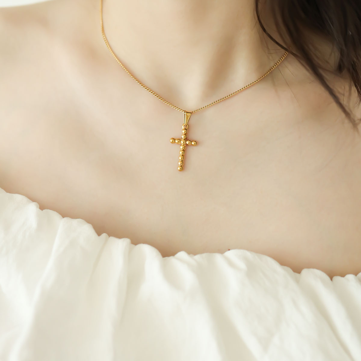 Women wear gold cross necklace.