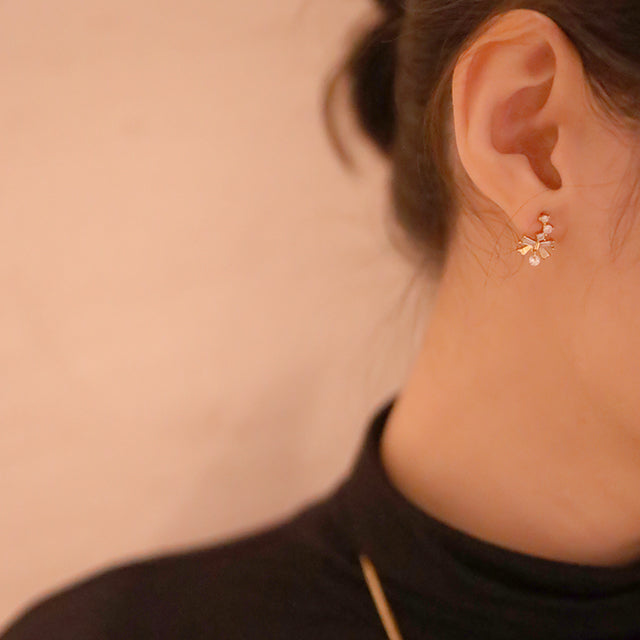 Gold ear studs on women ear.