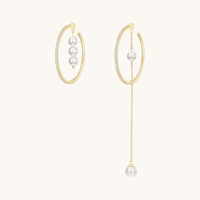 A pair of gold pearl drop earrings.