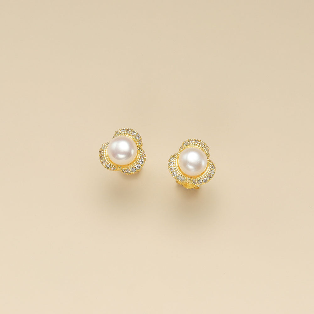 A pair of gold pearl stud earrings.