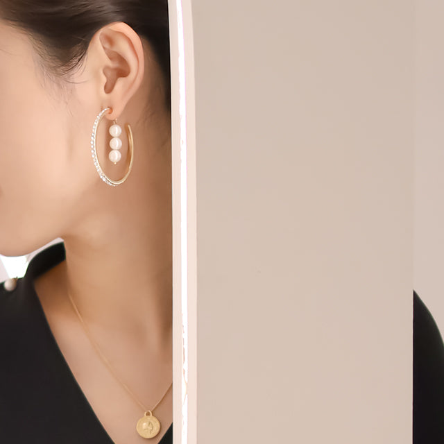 Gold plated hoop earrings on ear.