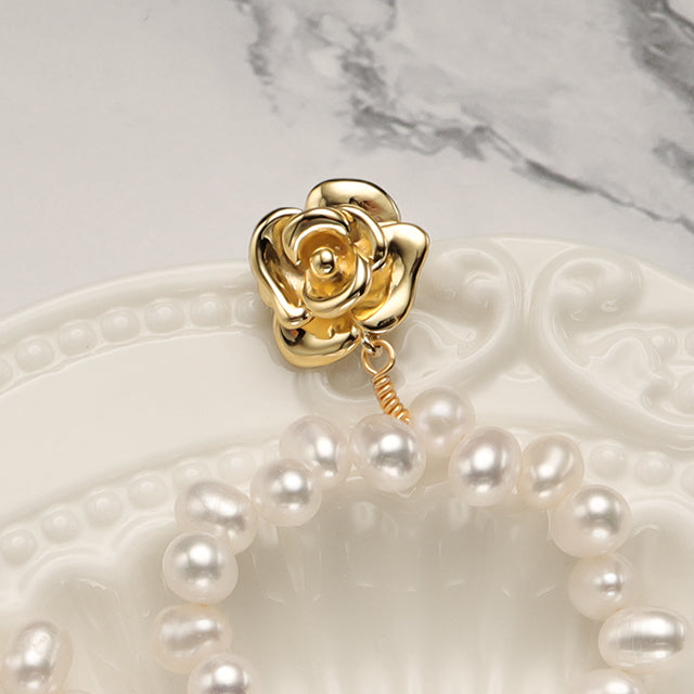 A close shot gold rose dangle earrings.