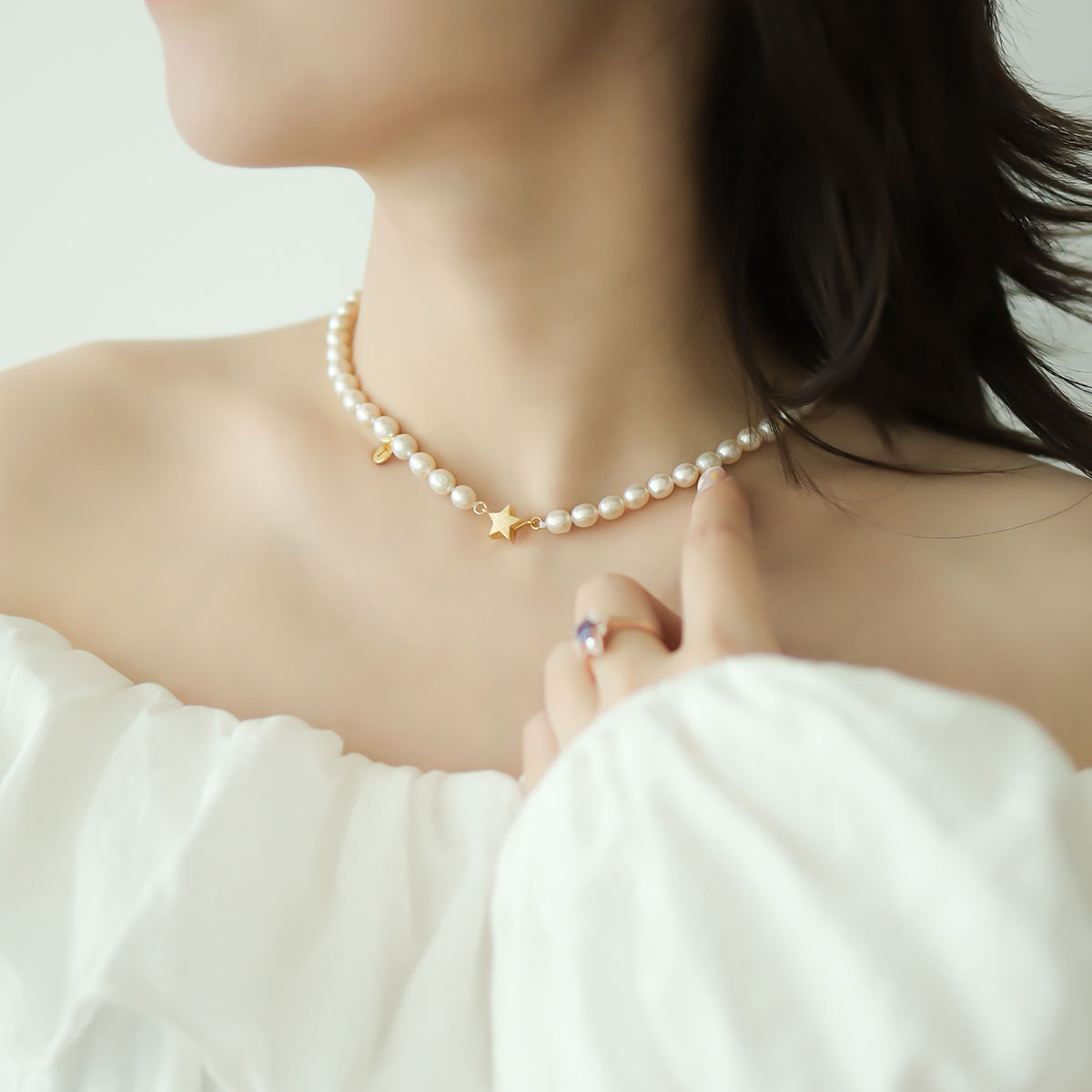 Women in white wear gold star choker.