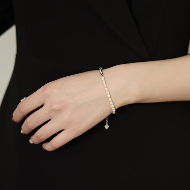 Women in black wear handmade bracelets.