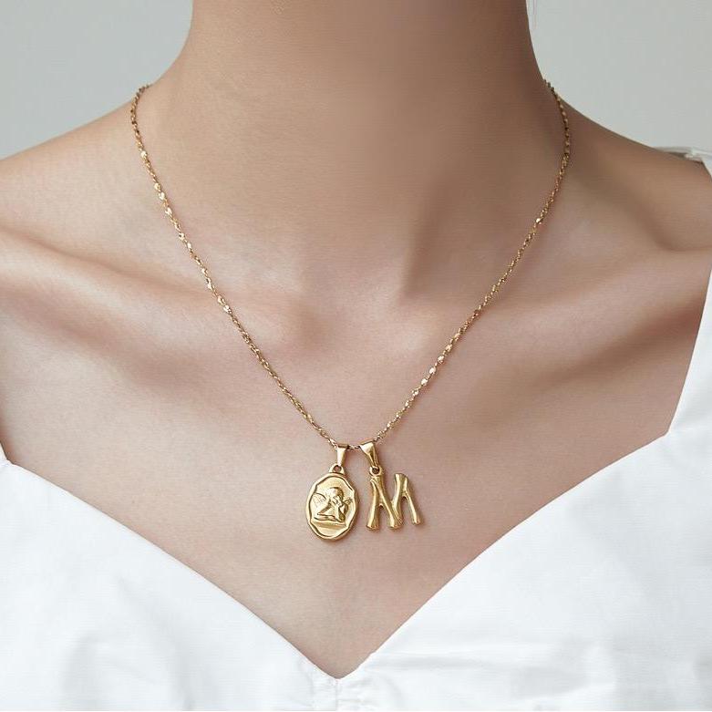 Woman wear initial charm necklace,