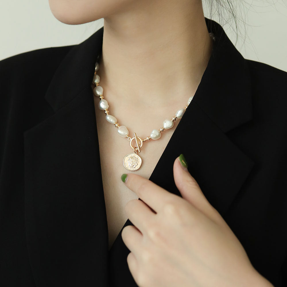 Women wear large baroque pearl pendant.