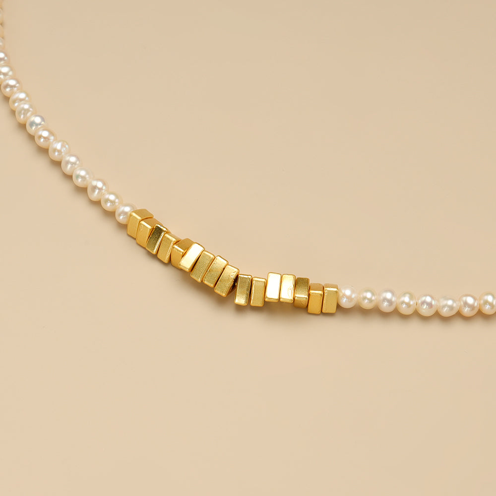 The close shot of pearl and gold necklace.