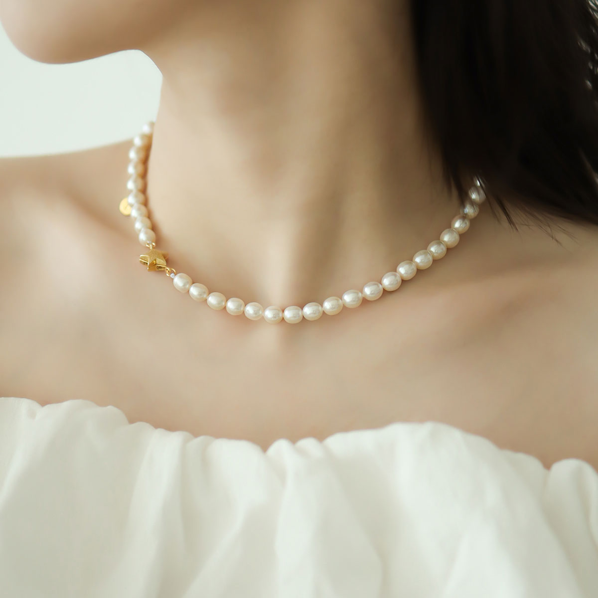 Women wear pearl and gold necklace.