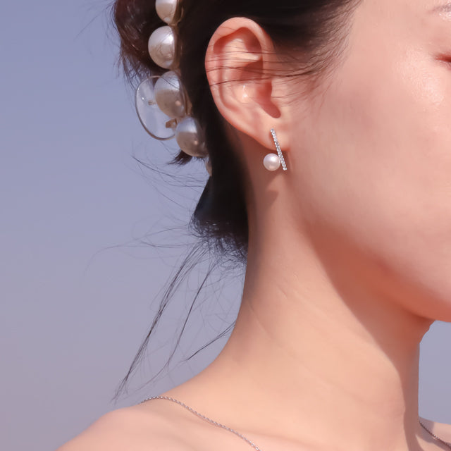 Pearl bridal earrings on women ear.