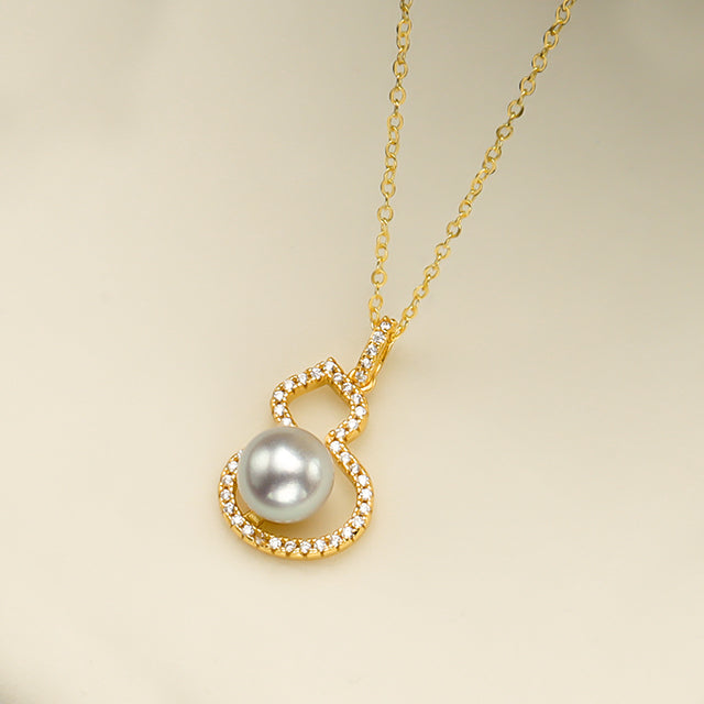 A gold gourd pendant with white pearl.