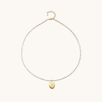 A pearl necklace with gold charm.