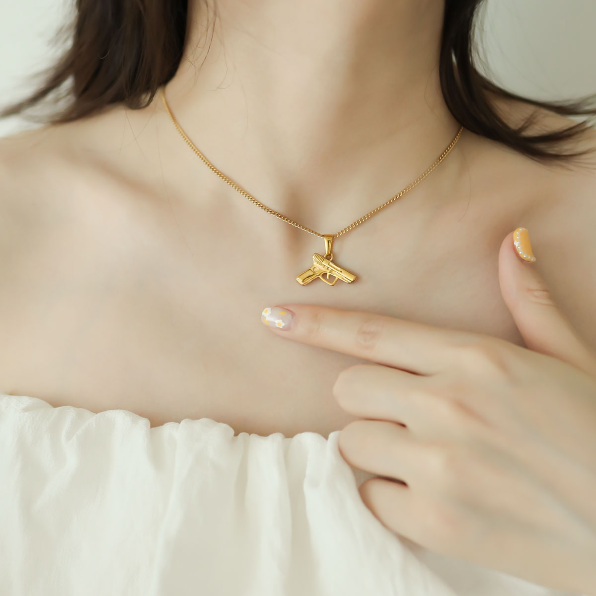 Women wear a pistol pendant.