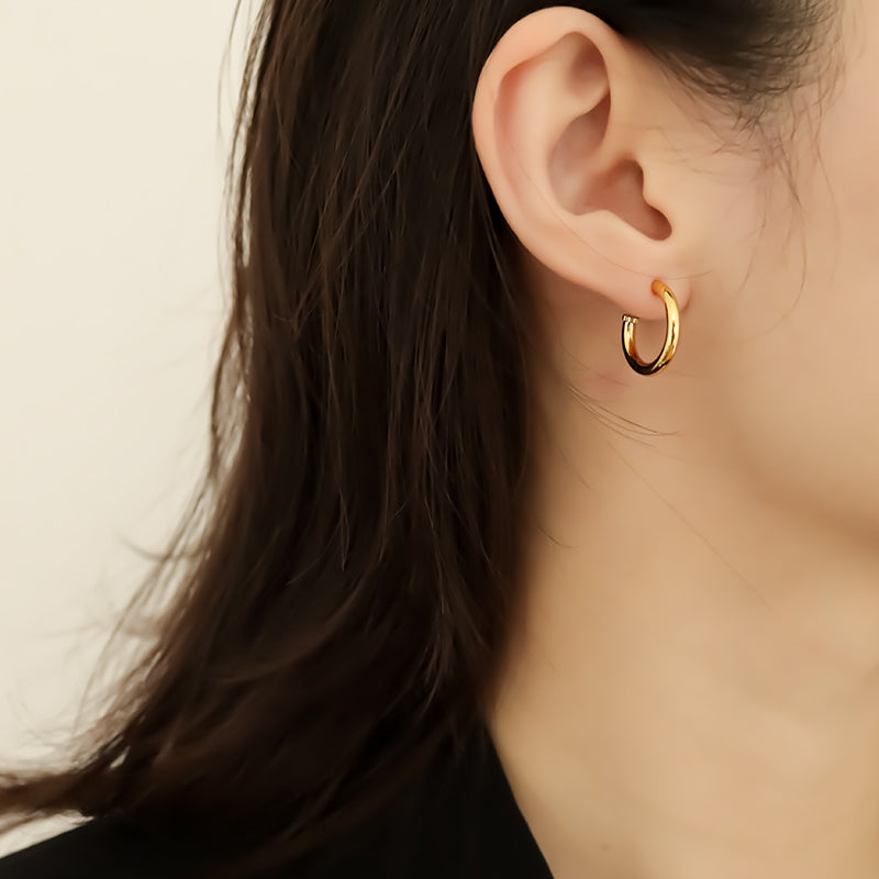 The side shot of round hoop earring wearing on women ear.