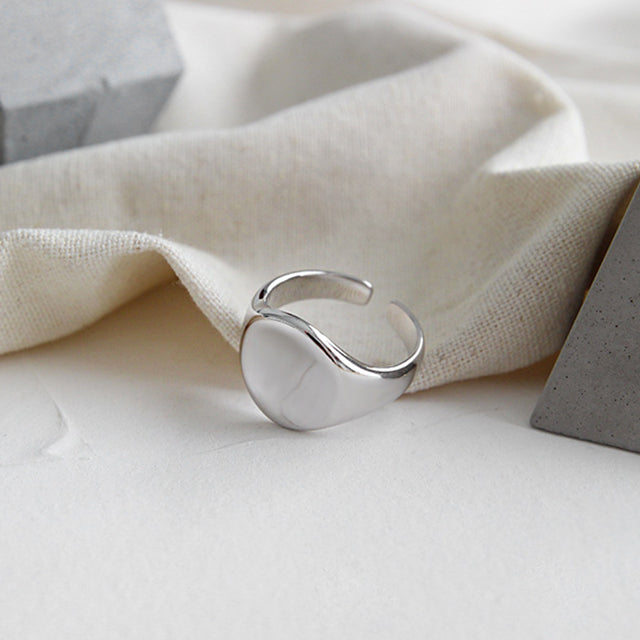 A silver circle ring on rutic cloth.