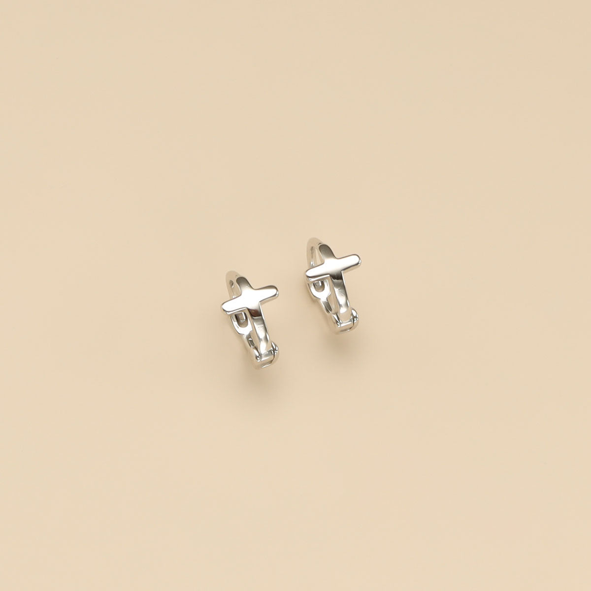 A pair of silver huggie hoop earrings.