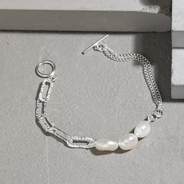 A silver stylish bracelet on cement block.