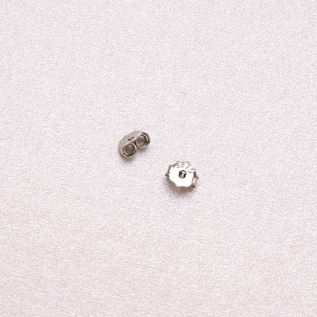 A pair of small earrings design backs.