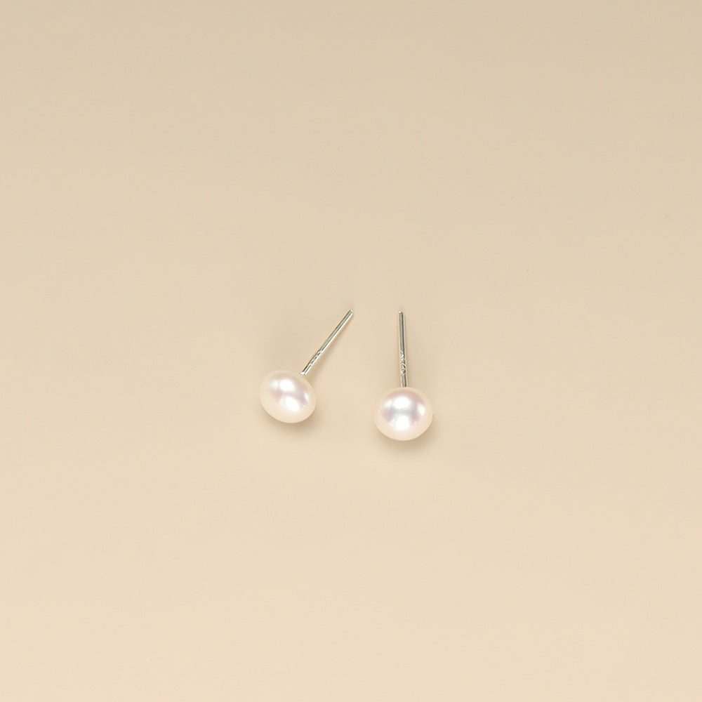 A pair of small pearl earrings.