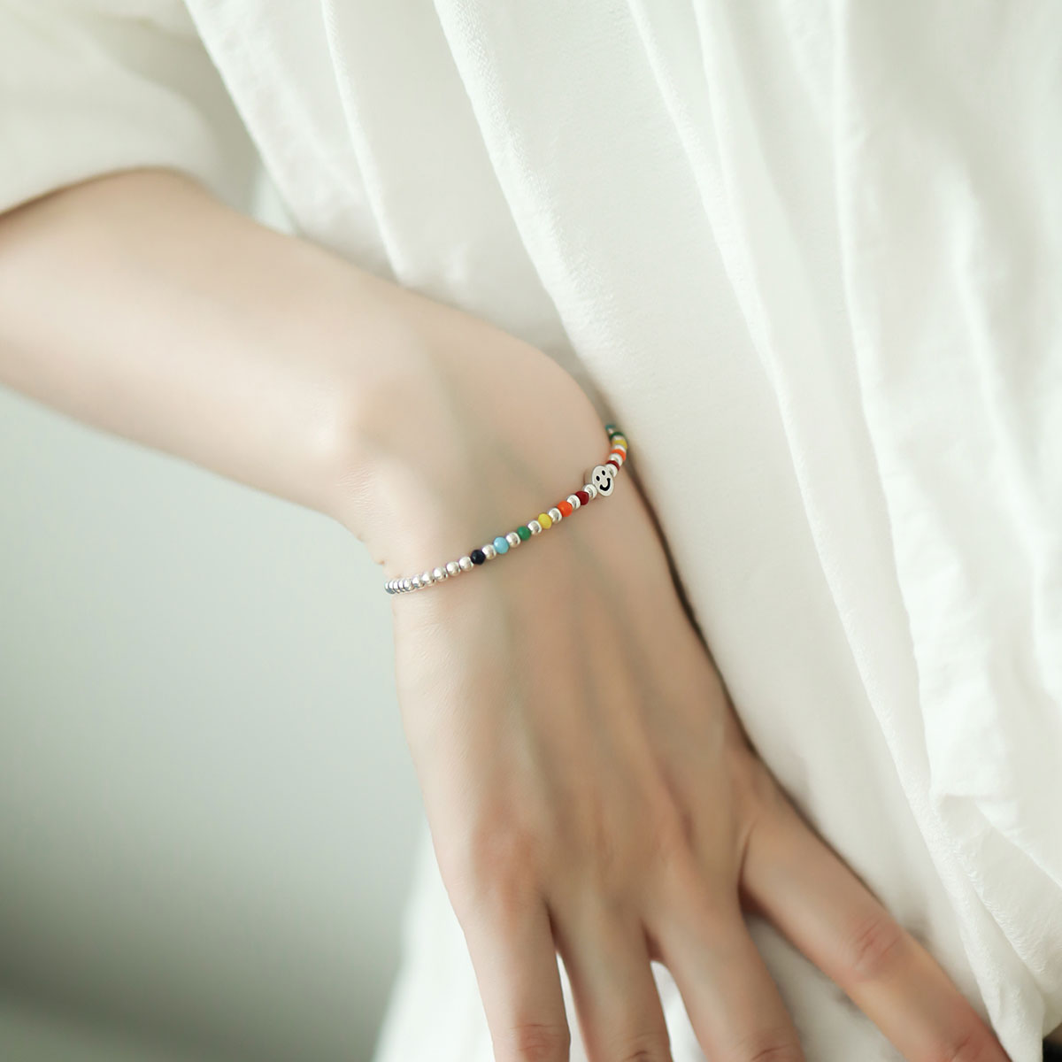 Small silver beaded bracelet on women wrist.