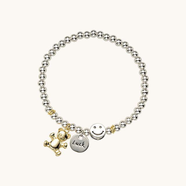 A solid silver bracelet with bear and luck coin charms.