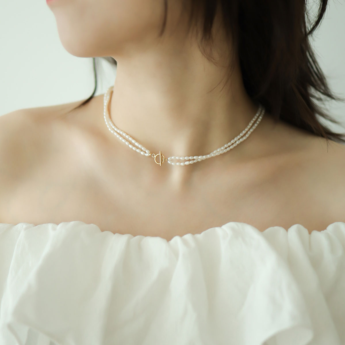 Women wear toggle pearl necklace.