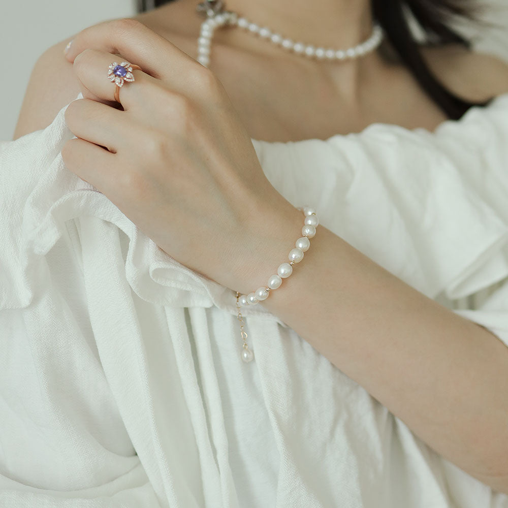 Women wear a white pearl bracelet.