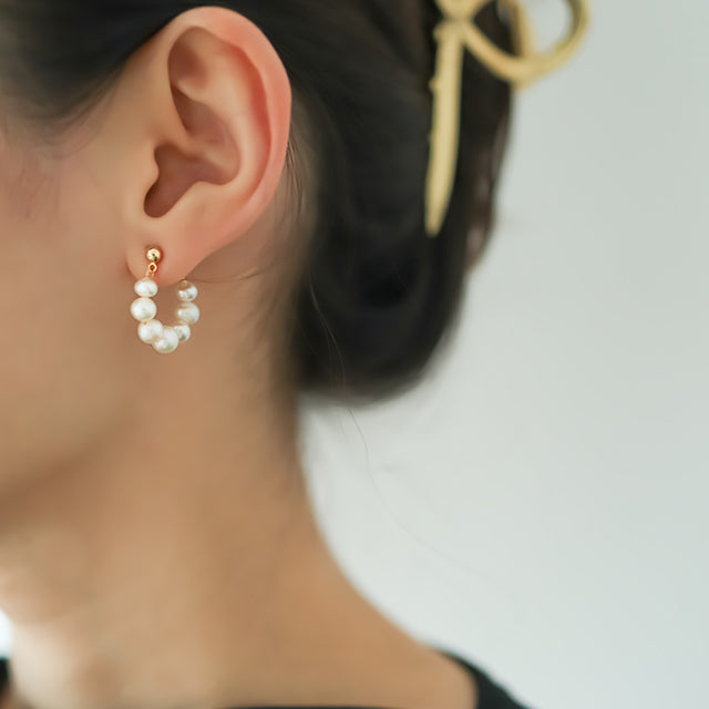 White pearl summer earrings on women ear.