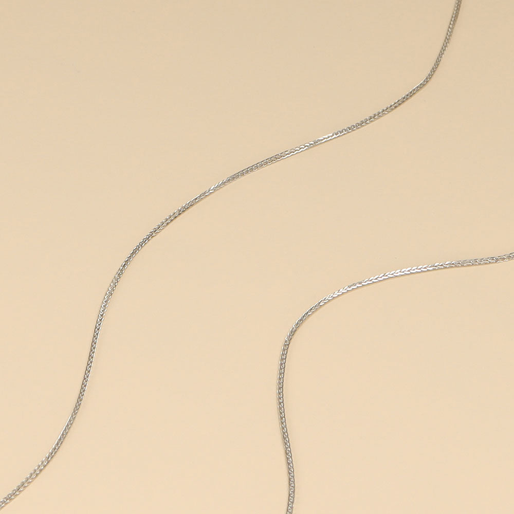 A close shot of white thin gold chain.